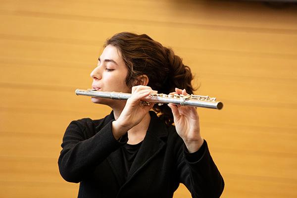 female college student plays the flute